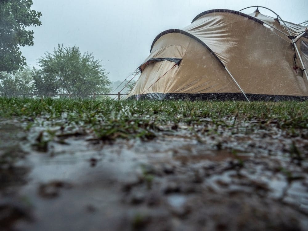 ぬかるんだ土地にテントを建てている画像